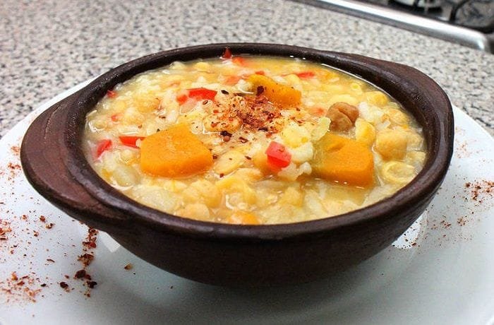 Chilean chickpeas with rice and squash in a clay bowl with merken