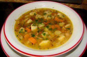 Chilean caldo de papas chilotas served in a clay bowl with harina tostada