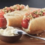 Chilean choripan served in a toasted marraqueta with fresh pebre