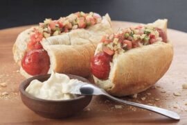 Chilean choripan served in a toasted marraqueta with fresh pebre
