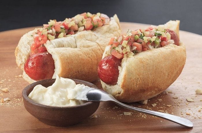 Chilean choripan served in a toasted marraqueta with fresh pebre