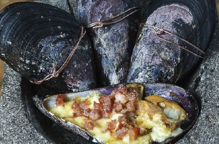 Chilean choritos al alicate, mussels sealed shut with wire, ready to be baked.