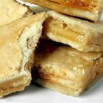 Layered Chilean chumbeque from Iquique, with a texture similar to nougat, on a wooden board ready to be cut.