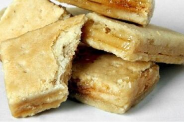 Layered Chilean chumbeque from Iquique, with a texture similar to nougat, on a wooden board ready to be cut.