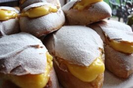 Golden Chilean conejitos sweet buns split open and filled with yellow pastry cream, dusted with powdered sugar