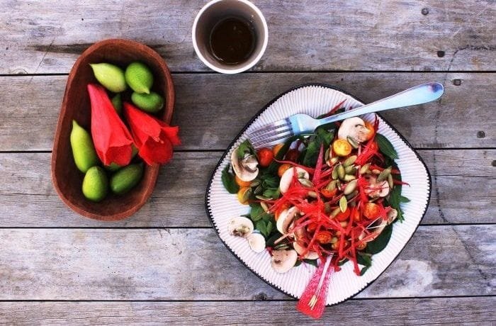 Chilean copihue salad with red petals, cherry tomatoes, mushrooms, and pumpkin seeds