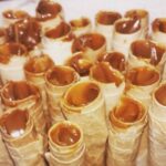 Chilean homemade cuchuflis filled with manjar and dipped in chocolate on a rack