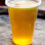 Chilean culen ponche served cold in a glass, a golden traditional herbal punch.