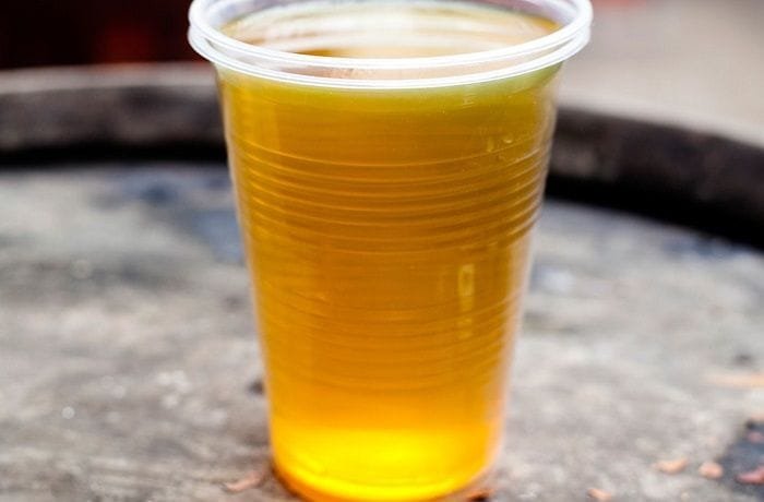 Chilean culen ponche served cold in a glass, a golden traditional herbal punch.