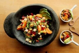 Chilean digüeñes ceviche with avocado, red onion, and cilantro in a clay dish