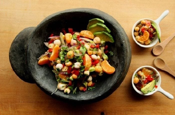 Chilean digüeñes ceviche with avocado, red onion, and cilantro in a clay dish