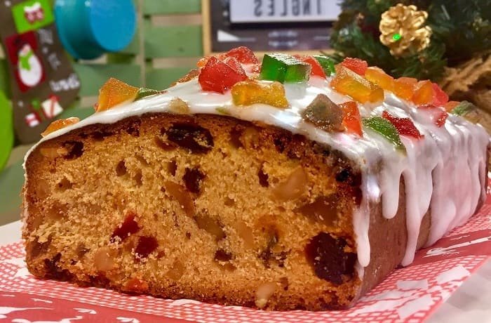 Chilean queque ingles, a loaf fruit cake with candied fruit, nuts, and raisins under a sugar glaze
