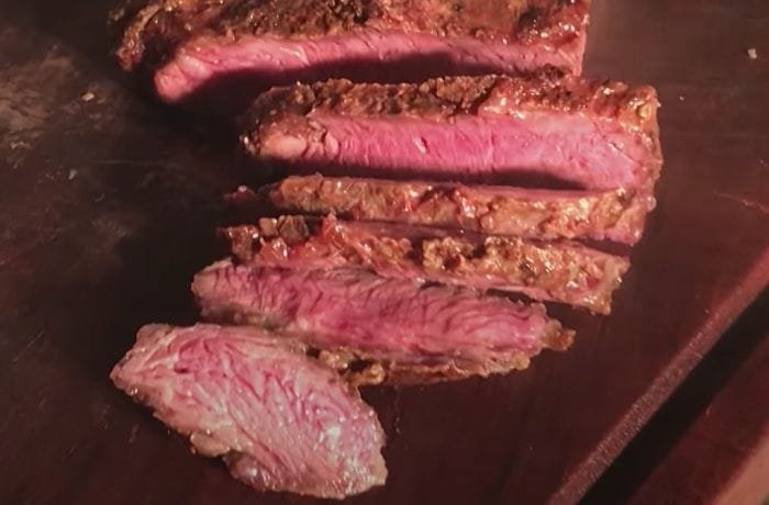 Chilean asado carnicero grilled over charcoal and sliced on a wooden board