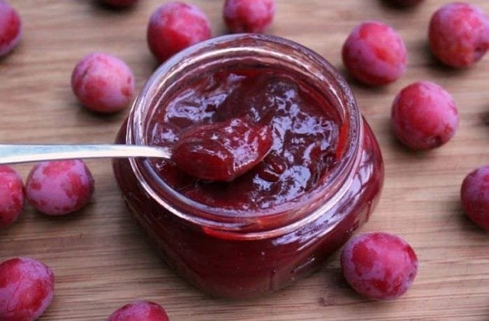 Chilean plum jam in glass jars, with dark red fruit