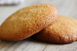 Homemade Chilean honey cookies, golden and baked, stacked on a plate.