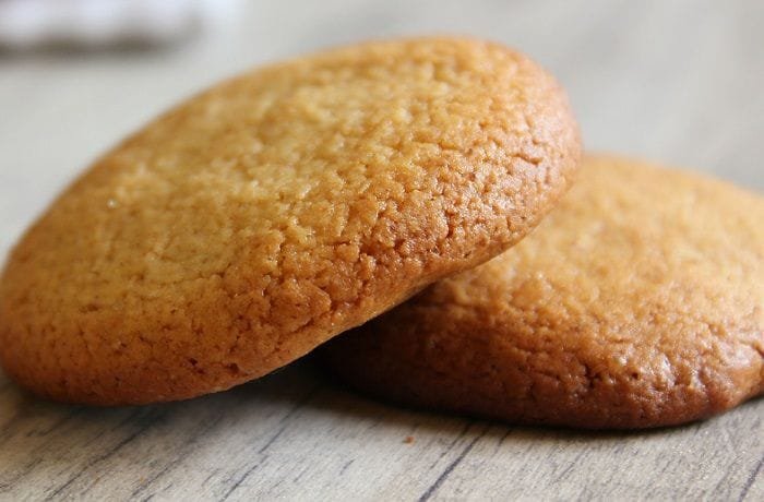 Homemade Chilean honey cookies, golden and baked, stacked on a plate.