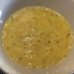 Chilean huevos a la ostra served in a bowl, a raw egg and lime mixture.