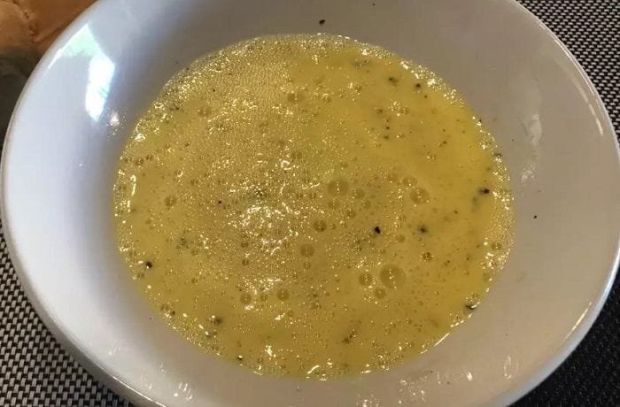 Chilean huevos a la ostra served in a bowl, a raw egg and lime mixture.