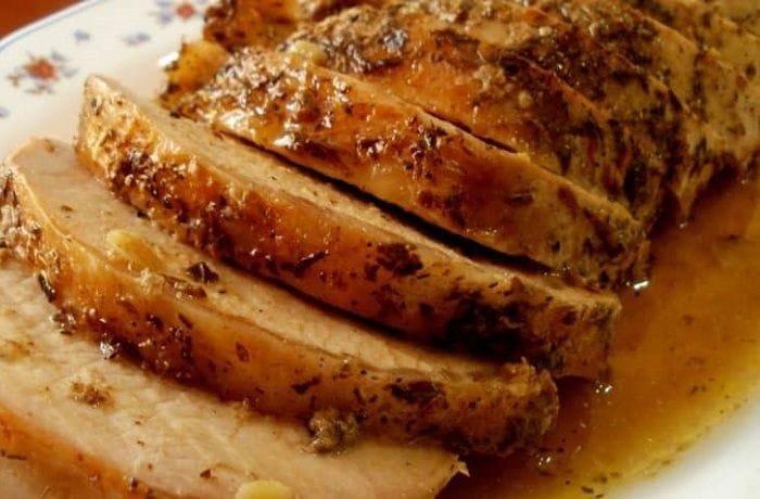 Juicy roast pork loin sliced and served with a reduced white wine and herb sauce