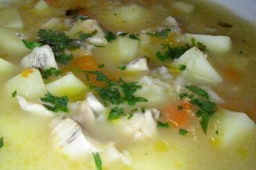 A deep bowl of Chilean loco carbonada with potatoes and carrots, garnished with fresh parsley.