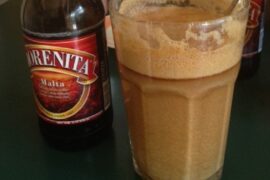 Large glass of Chilean malta con harina tostada, a cold energy drink made with dark beer and toasted flour.
