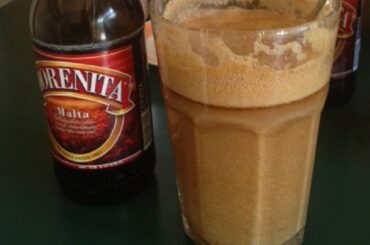 Large glass of Chilean malta con harina tostada, a cold energy drink made with dark beer and toasted flour.