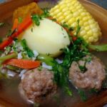 Chilean cazuela de albondigas, meatball soup with potato, squash, and corn in a deep bowl