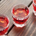 Small glass of homemade Chilean murtado, a reddish murtilla berry liqueur.