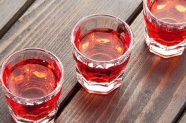Small glass of homemade Chilean murtado, a reddish murtilla berry liqueur.