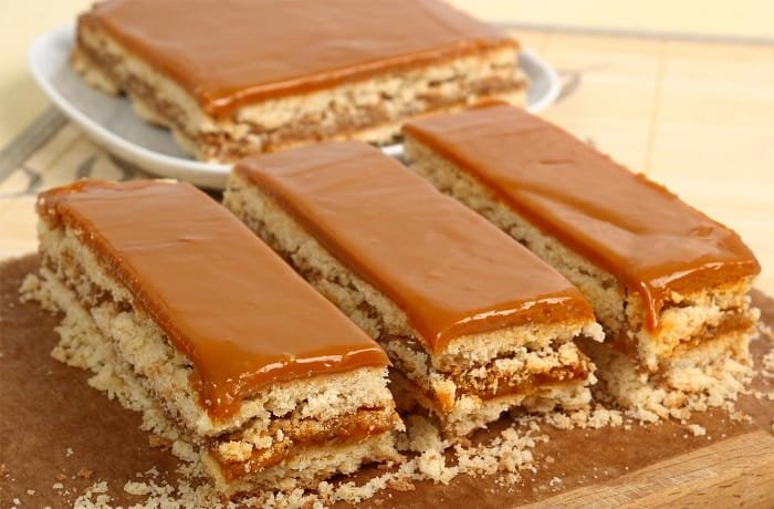 Chilean no-bake galletas de vino cake layered with manjar and topped with grated coconut