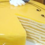 Tall Chilean orange pancake cake in thin layers, covered with orange cream and chocolate decoration