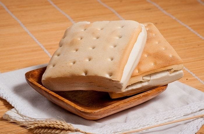 Freshly baked Chilean pan coliza on a plate, showing its square shape and soft crumb.