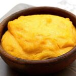 Chilean pastel de chuchoca served in an individual clay dish with a golden top layer.