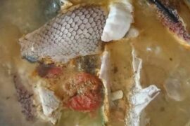 Chilean caldillo de pejeperro in a clay bowl with fish, potatoes, and parsley