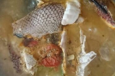 Chilean caldillo de pejeperro in a clay bowl with fish, potatoes, and parsley