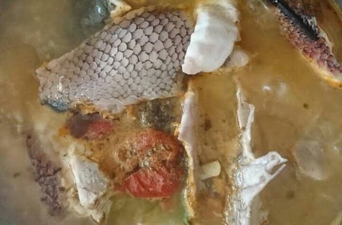 Chilean caldillo de pejeperro in a clay bowl with fish, potatoes, and parsley