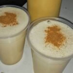Chilean picoroco ponche served in a tall glass, topped with ground cinnamon.