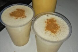 Chilean picoroco ponche served in a tall glass, topped with ground cinnamon.