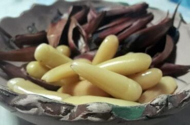Chilean pine nuts in syrup, glossy and golden, served as a gourmet dessert topping.