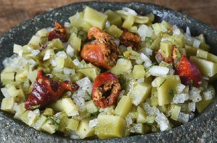 Chilean salad of red piures and olive-green ulte with onion, cilantro, and green chili
