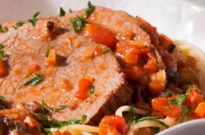 Chilean pollo ganso a la olla, eye of round pot roast served in slices with carrots and thick gravy