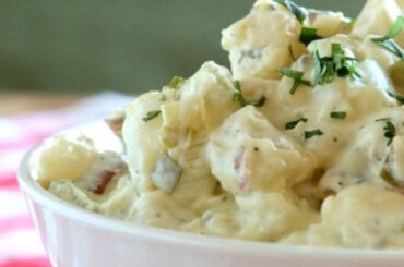 Bowl of Chilean potato salad with mayonnaise, diced celery and onion, sprinkled with fresh chives