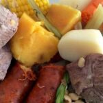 Plate of Chilean puchero seco with beef, pork ribs, corn, potatoes, and seasonal vegetables
