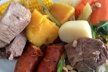 Plate of Chilean puchero seco with beef, pork ribs, corn, potatoes, and seasonal vegetables