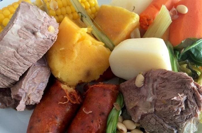 Plate of Chilean puchero seco with beef, pork ribs, corn, potatoes, and seasonal vegetables