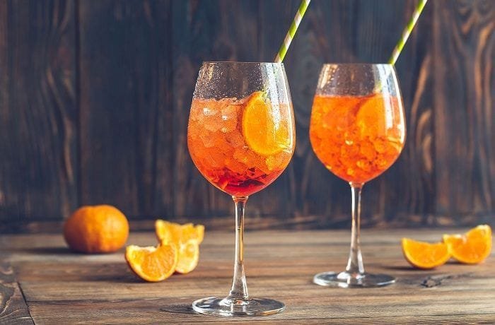 Ramazzotti Spritz cocktail served in a tall wine glass with orange slices and ice.