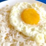 Chilean arroz con huevo, fluffy white rice topped with a runny fried egg and merken