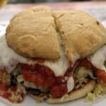 Chilean rumano completo sandwich with beef and pork patty, tomato sauce, sauerkraut, and mayonnaise