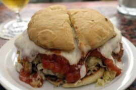 Chilean rumano completo sandwich with beef and pork patty, tomato sauce, sauerkraut, and mayonnaise