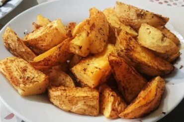 Tray of rustic skin on roasted potatoes, golden and seasoned with oregano and merken